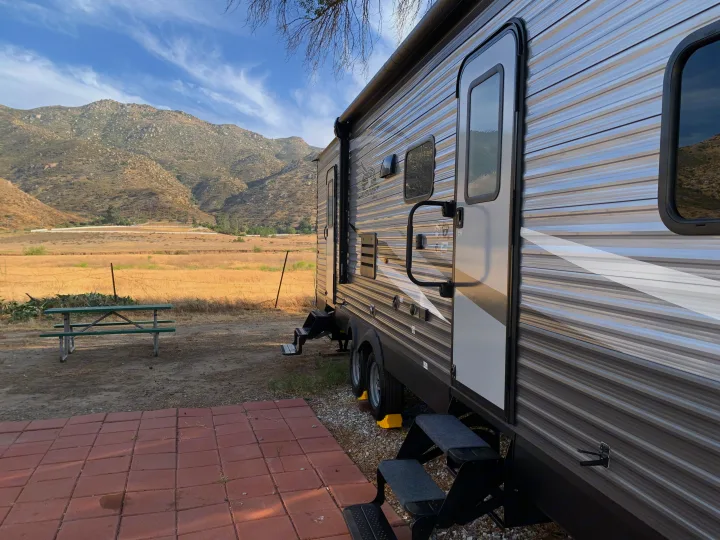 Enjoy an RV rental adventure! This travel trailer is set at a scenic mountain campsite with a patio and picnic table.. Jayco Jay Flight SLX 2021