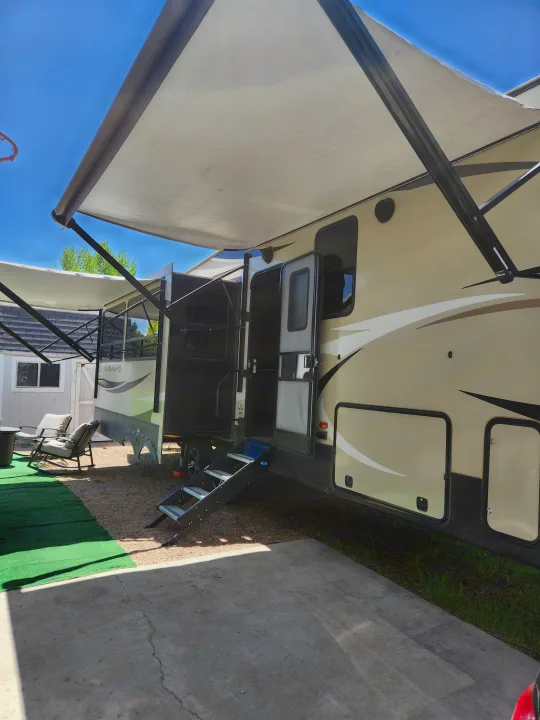 Enjoy comfort in this travel trailer RV rental, featuring an extended awning, steps, and outdoor living space.. Keystone RV Cougar 2019