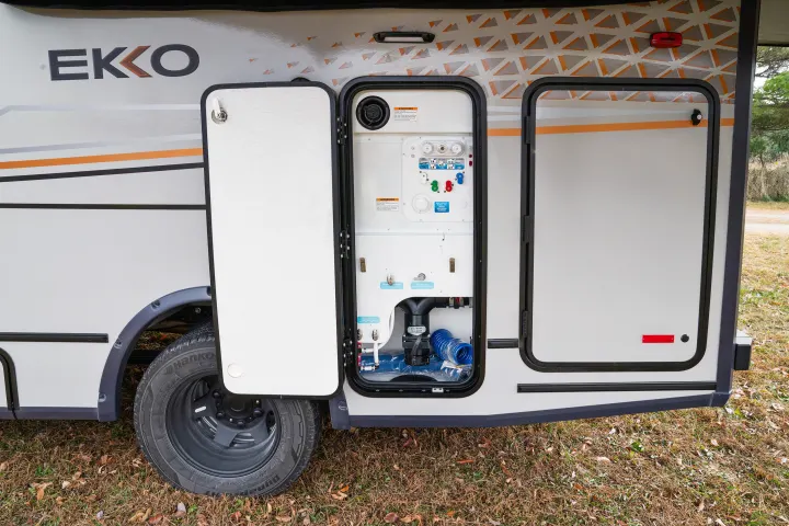 EKKO RV rental utility access open, detailing water hookups, colored valves, and gray waste connections.. Winnebago EKKO POP TOP 2027
