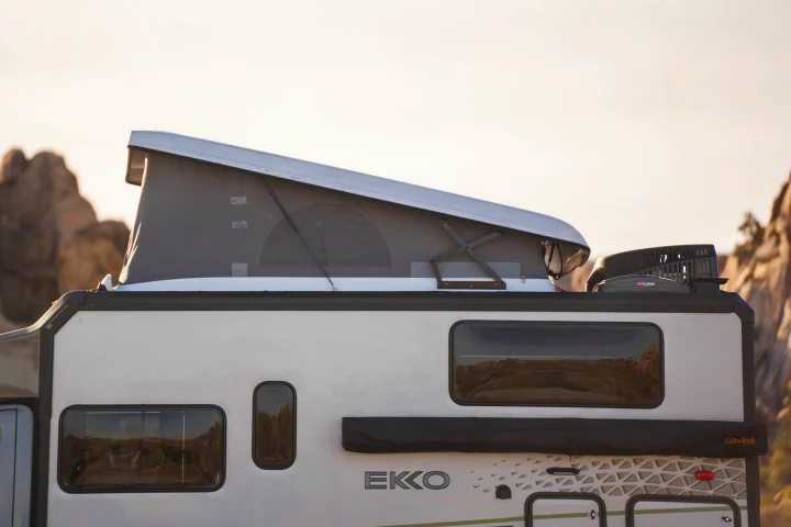 An EKKO RV rental with an open pop-top tent, ideal for outdoor adventures, shown with a MaxxAir fan.. Winnebago EKKO POP TOP 2027