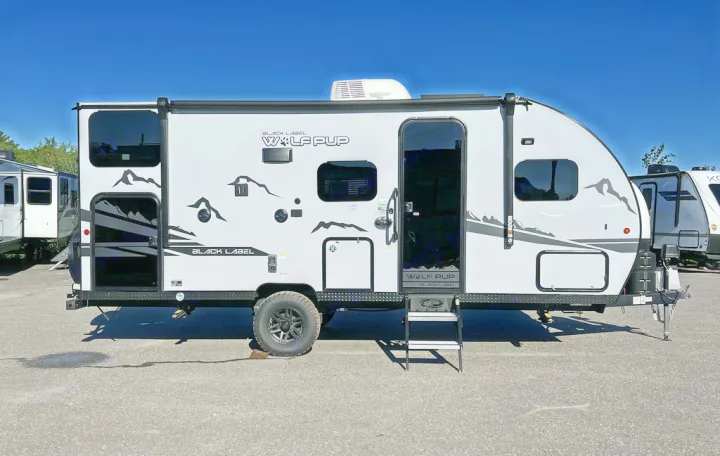 White Wolf Pup Black Label travel trailer with mountain graphics, perfect for your next RV rental adventure.. Forest River Cherokee Wolf Pup Black Label 2022