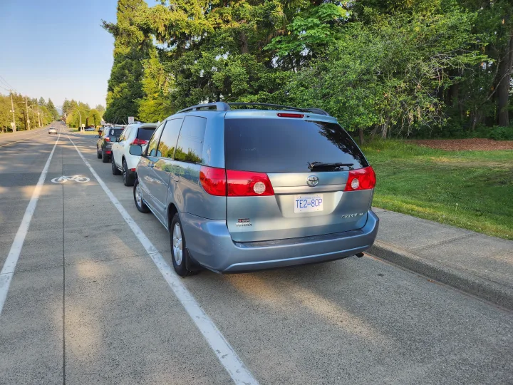 Blue Toyota Sienna minivan parked roadside. A family vehicle for travel, unlike an rv rental.. Toyota Sienna 2008