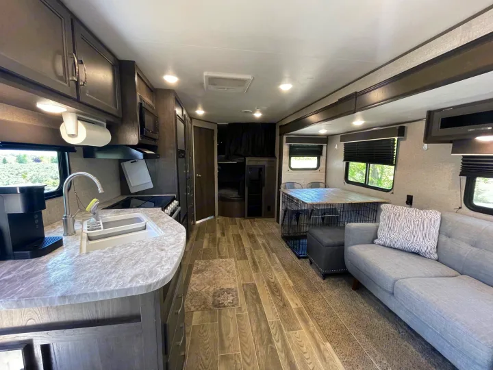 Explore this comfortable RV rental interior: full kitchen, living room with sofa, dining table, and pet-friendly amenities.. Jayco Jay Flight SLX 2021