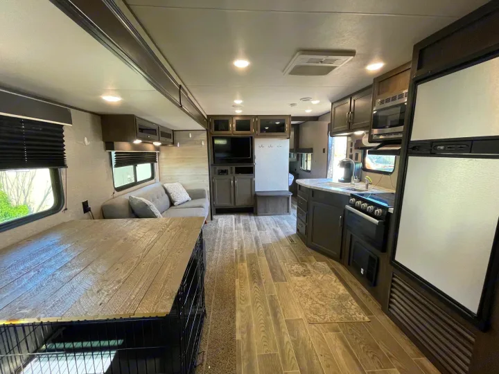 Spacious rv rental interior: modern living area with couch, entertainment center, and a fully equipped kitchen. Ideal for road trips.. Jayco Jay Flight SLX 2021