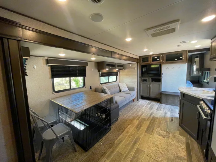 Spacious, modern RV rental interior featuring living, dining (with a dog crate table), and kitchen areas. A comfortable travel home.. Jayco Jay Flight SLX 2021