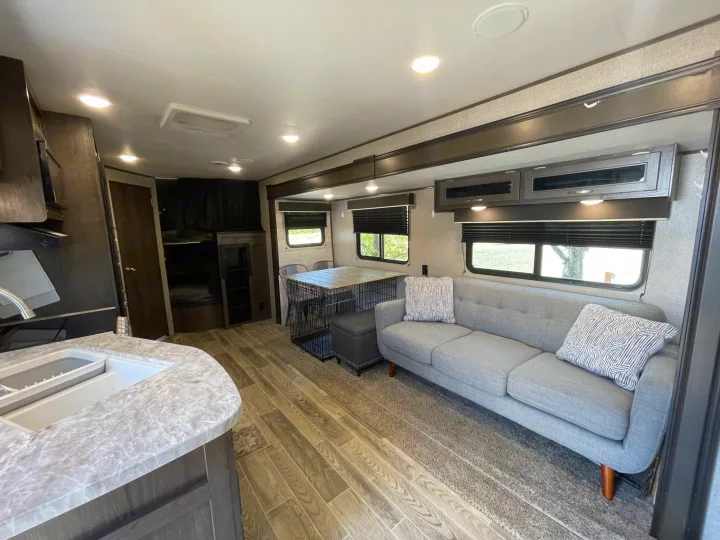 RV rental interior showcases a bright, modern living area with sofa, dining, kitchen, and bunk beds. Perfect for comfortable travel.. Jayco Jay Flight SLX 2021