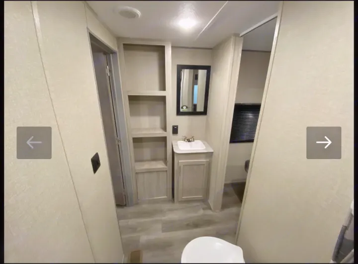This RV rental features a compact bathroom with a vanity, sink, mirror, and built-in shelving for efficient storage.. Coachmen Catalina 2023