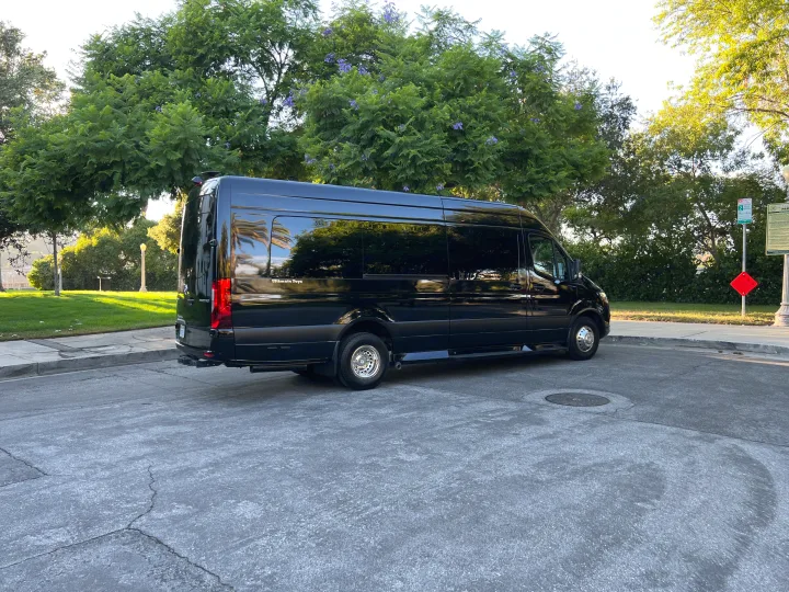 Black "Ultimate Toys" Sprinter RV rental parked in a scenic park area. Ideal for luxury travel.. Ultimate Toys Ultimate Coach 2023