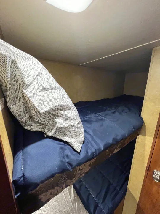 RV rental: Compact bunk beds with dark blue comforters & patterned pillow, ideal for travel rest.. Jayco Jay Flight Swift 154 BH Slx 2013