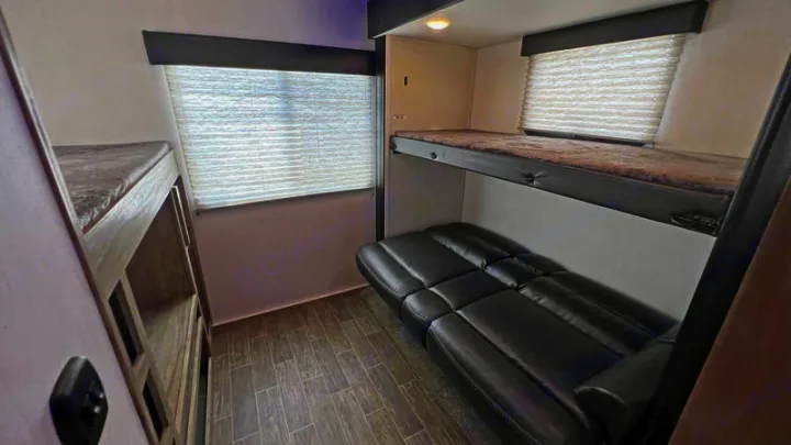 Versatile RV rental interior with bunk beds and a comfortable sofa, perfect for family adventures.. Forest River Cherokee Arctic Wolf 2022