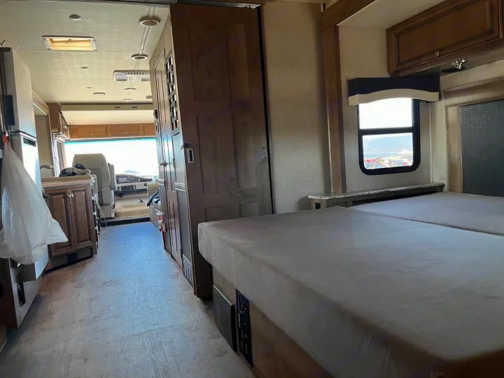 View inside an RV rental, from the beds looking down the hallway past the kitchen to the driver's seat.. Flair-Fleetwood Flair-Fleetwood Motorhome 2020