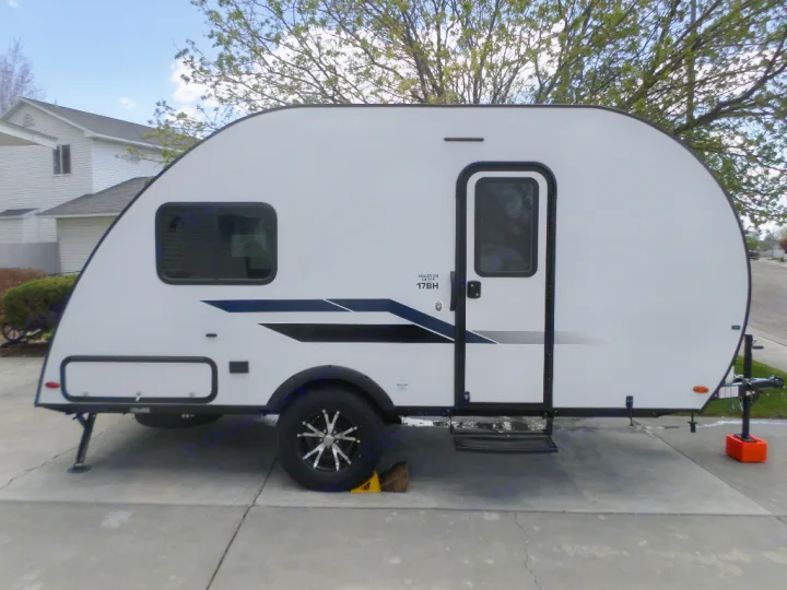 A modern white Shasta Oasis 17BH travel trailer, ideal for rv rental, sits on a concrete driveway.. Braxton Creek Bushwhacker Plus 2022