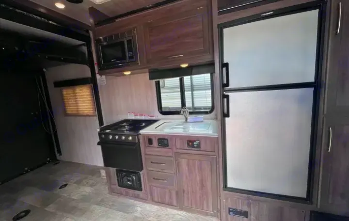 Spacious RV rental interior featuring a full kitchen with stove, fridge, microwave, and a versatile cargo area for adventure.. Genesis Supreme Rv Genesis Supreme 2021