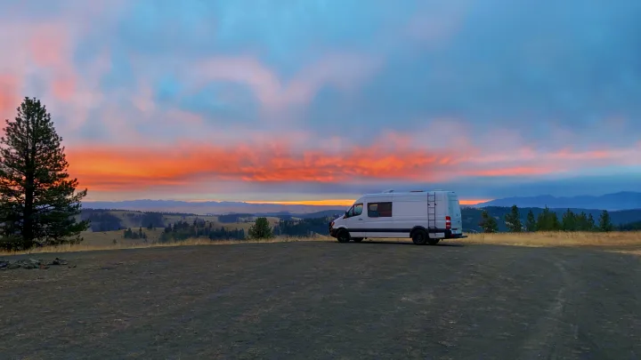 White RV rental van at sunset/sunrise, offering stunning views of mountains and nature for your next adventure.. Mercedes-Benz Sprinter 2017