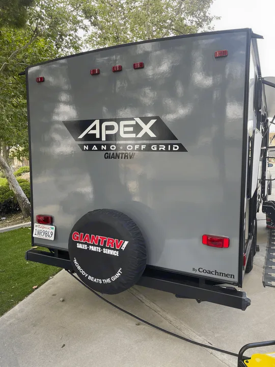 Rear of an Apex Nano "Off Grid" RV travel trailer with Giant RV branding, ideal for an RV rental. CA plate shown.. Coachmen Apex Nano 2021