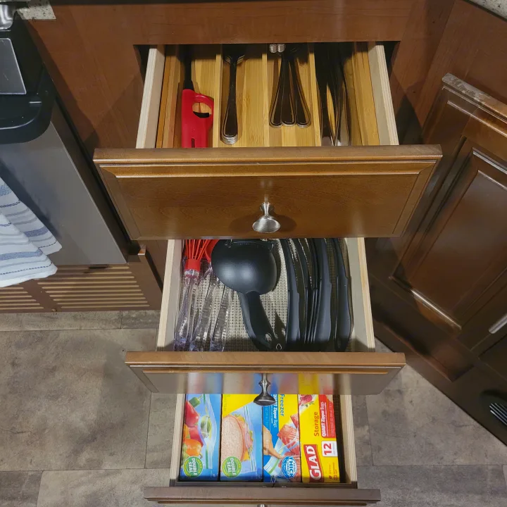 RV rental kitchen: Open drawers reveal organized silverware, cooking utensils, and Glad storage bags for practical travel living.. Georgetown GT5 2017
