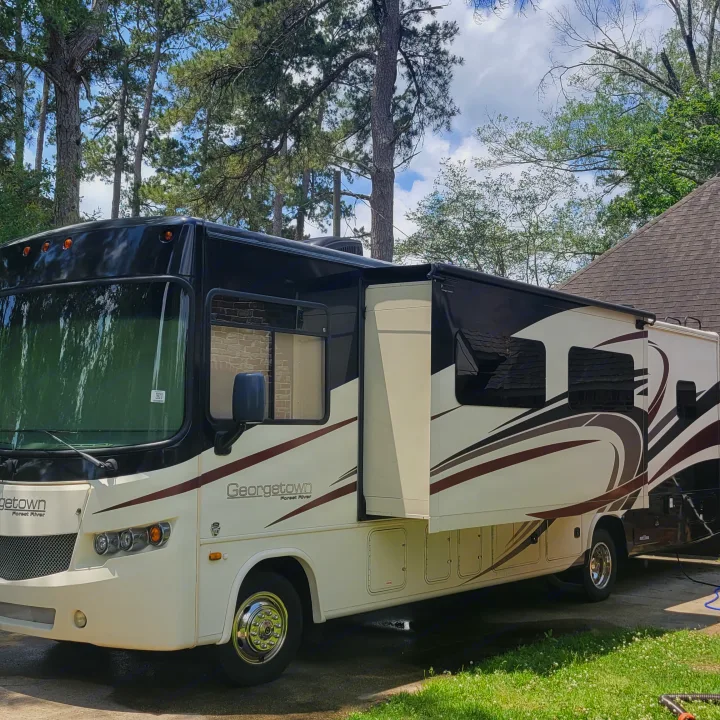 Spacious Georgetown Forest River RV rental with extended awning and slide-out, parked in a tree-lined driveway.. Georgetown GT5 2017