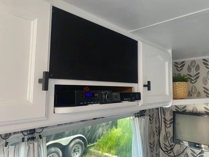 RV rental: Built-in entertainment area with white cabinets, Pyle audio receiver (96.3 FM), media devices, and TV.. Dutchmen Lite 2007