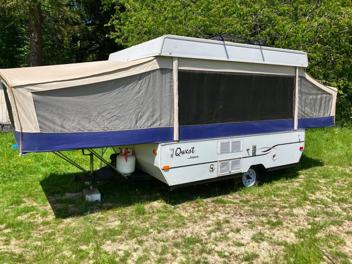 This Jayco Qwest pop-up camper is set up outdoors, ready for your next RV rental and camping adventure.. Jayco Qwest 2003