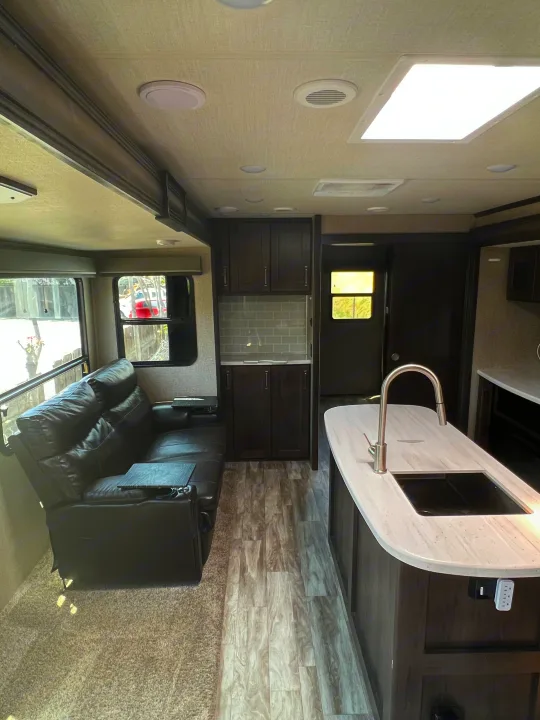 RV rental: Modern kitchen, cozy recliners, and wood-look flooring blend in this spacious interior.. Grand Design Reflection 2022