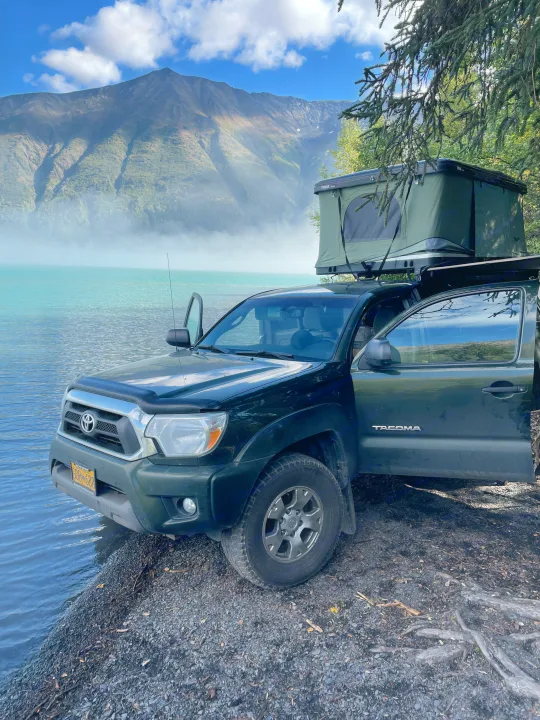 RV rental ready truck camping: Toyota Tacoma with rooftop tent beside a stunning misty lake and mountains.. Toyota Tacoma 2012