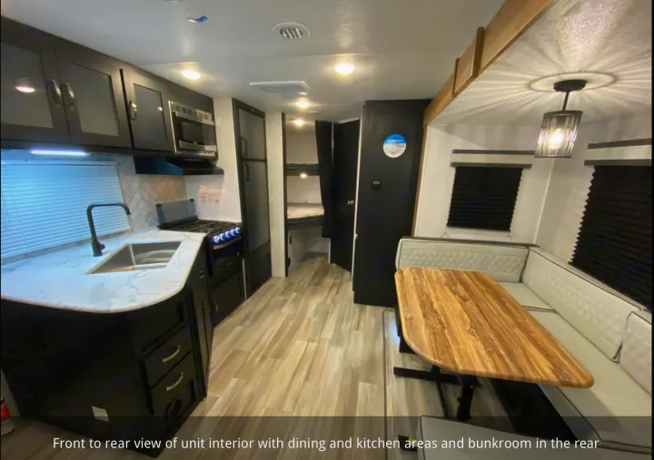 Explore this RV rental's inviting interior: sleek kitchen, comfortable dining space, and rear bunkroom for extra sleeping.. Coachmen 257BHS 2022