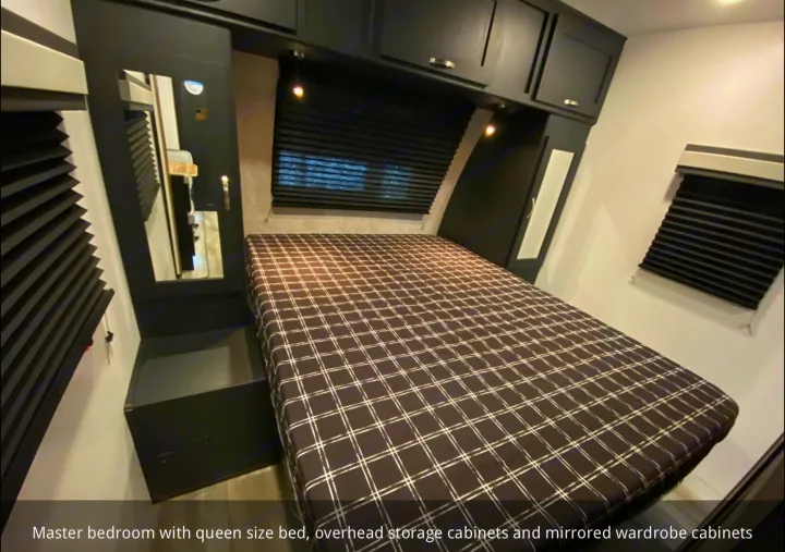 RV rental master bedroom: queen bed, overhead and mirrored wardrobe cabinets, offering comfort and storage.. Coachmen 257BHS 2022