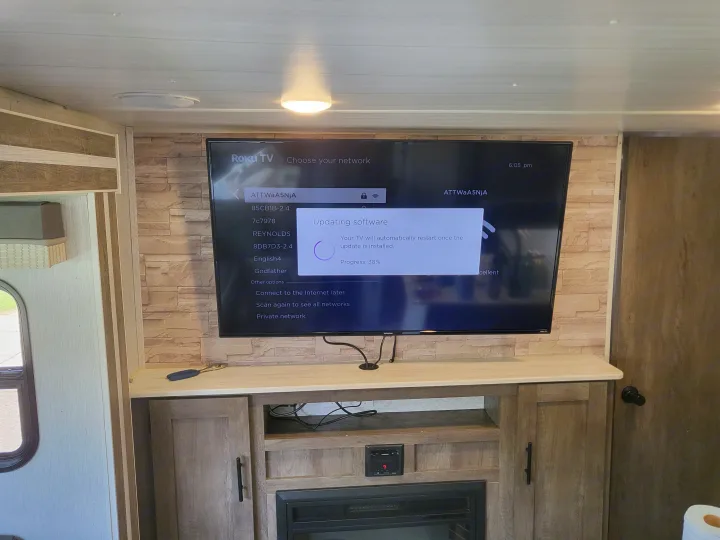 Inside an RV rental, a Roku TV shows 'Updating software' at 38% progress, with a list of Wi-Fi networks visible.. Forest River Wildwood X-Lite 2022