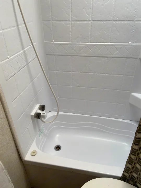 Clean, compact white bathtub and shower unit in an RV rental, with molded tile walls and a handheld shower. Perfect for travel.. Jayco Jay Flight SLX 2018