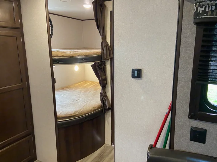 Inside an RV rental: Comfortable bunk beds with privacy curtains and individual lights. Features include a Dometic thermostat.. Jayco Jay Flight SLX 2018