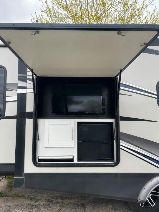 This RV rental offers outdoor entertainment: a TV, small fridge, and storage in an accessible compartment.. Keystone RV Bullet Premier Ultra 2020