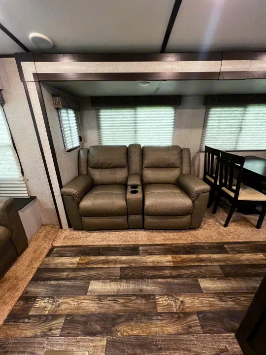 Cozy RV rental interior with comfy recliners, dining space, and mixed flooring. Perfect for your next adventure!. Keystone RV Bullet Premier Ultra 2020