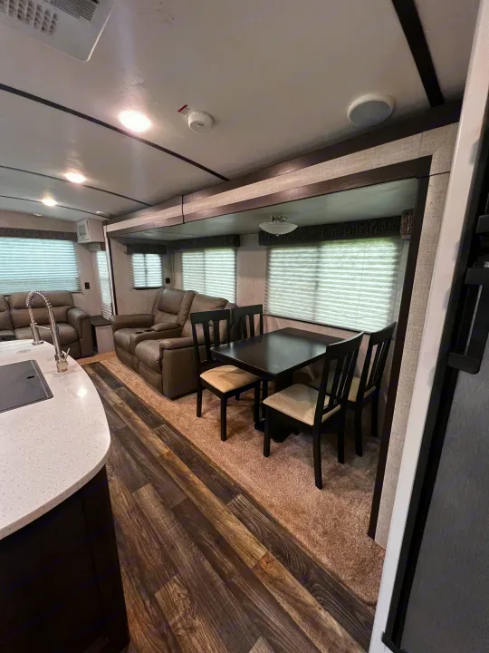 RV rental interior: a cozy living area with recliners, dining table, and kitchen for your travels.. Keystone RV Bullet Premier Ultra 2020