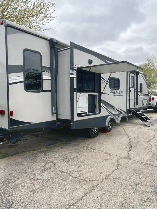 Modern travel trailer with outdoor kitchen, ideal for RV rental adventures. Spacious and ready for your trip!. Keystone RV Bullet Premier Ultra 2020