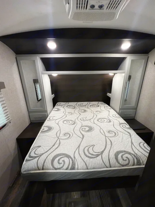 Compact RV rental bedroom featuring a comfortable bed, ample storage, and AC for a pleasant journey.. Keystone RV Bullet Premier Ultra 2020