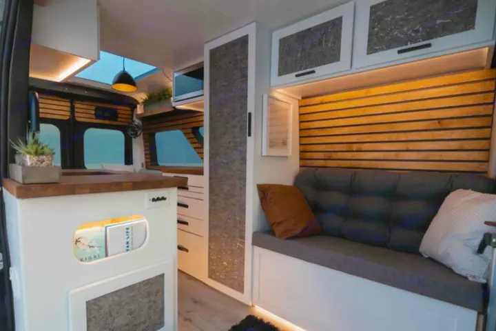 Experience comfort in this custom rv rental van. Features a modern kitchen, cozy lounge with slatted wall, and ambient lighting.. Dodge B Van 2020
