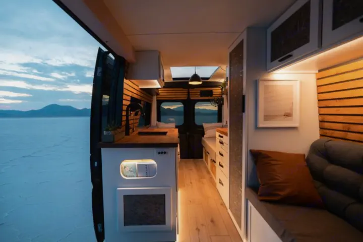 Experience mobile living! This modern RV rental interior features a kitchen, seating, and stunning salt flat views.. Dodge B Van 2020