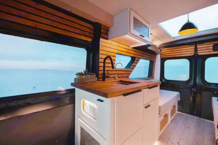 RV rental: Inside a modern camper van with a cozy kitchenette, wood details, and panoramic views for comfortable mobile living.. Dodge B Van 2020