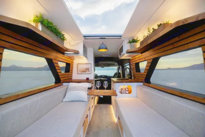Experience travel with this custom RV rental, boasting a modern wood interior, cozy seating, and expansive scenic window views.. Dodge B Van 2020