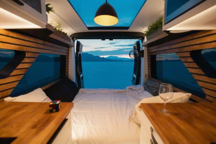 Cozy **RV rental** interior with a stunning lake and mountain view from the back. Perfect for travel adventures.. Dodge B Van 2020