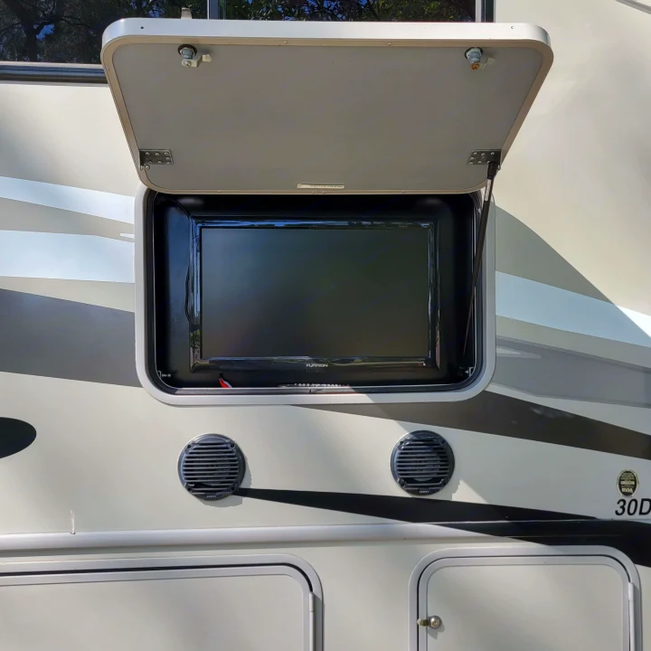 An outdoor TV and speakers built into an RV's side, ready for entertainment during an RV rental trip. Perfect for camping fun.. Forest River Fr3 2015