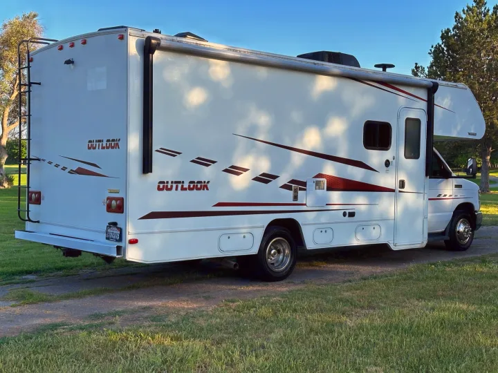 White Winnebago "Outlook" RV rental, Class C motorhome, parked on grass. Perfect for your next adventure.. Winnebago Outlook 2019