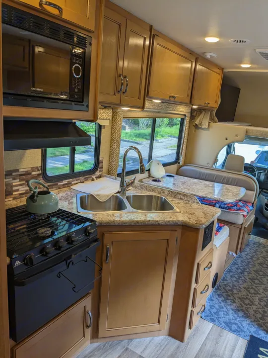 Step inside this RV rental! A complete kitchen with microwave, stove, sink, and a cozy dinette awaits your travels.. Thor Freedom Elite 2017