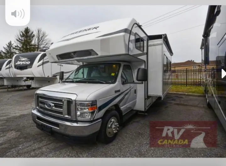 This white Class C RV motorhome, with its extended slide-out, is seen at a dealership, ready for rv rental adventures.. Forest River Sunseeker LE 2023