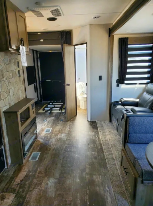 RV rental interior. Features a comfy living area, kitchenette with fireplace, and a rear garage with bathroom access.. Forest River Cherokee Wolf Pack Toy Hauler 2022