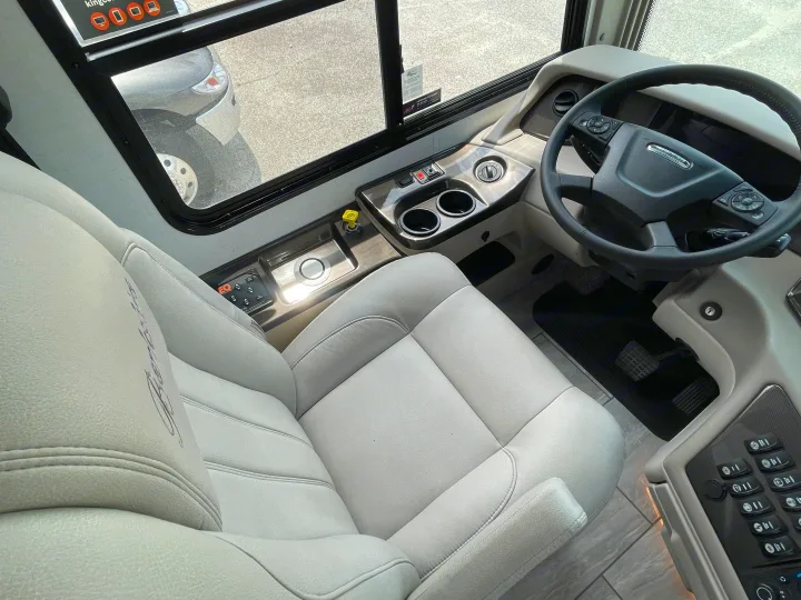 Experience comfort in this RV rental's spacious cockpit, featuring a light-gray driver's seat and modern controls.. Berkshire XLT 2023