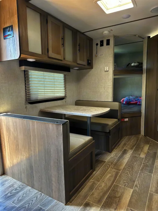 Clean RV rental interior featuring a dinette, sleek overhead cabinets, and cozy bunk beds for comfortable travel.. Gulf Stream Ameri-Lite Super Lite 2022