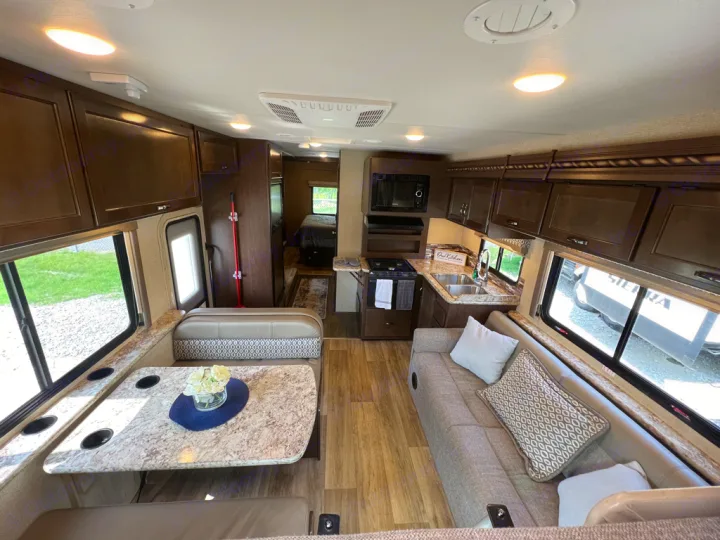 Explore this modern RV rental's inviting interior: full kitchen, dinette, sofa, and rear bedroom. Perfect for travel!. Thor Motor Coach Freedom Elite 2017