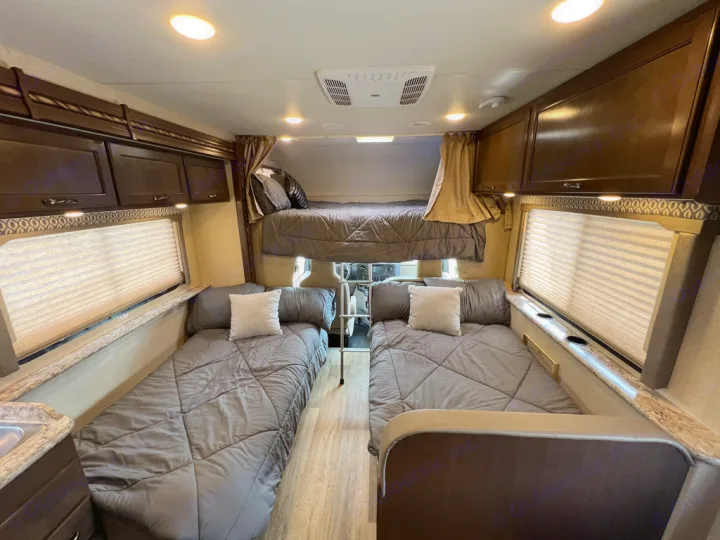 This RV rental interior offers three comfortable sleeping areas: an overhead bunk and two floor-level beds, perfect for groups.. Thor Motor Coach Freedom Elite 2017