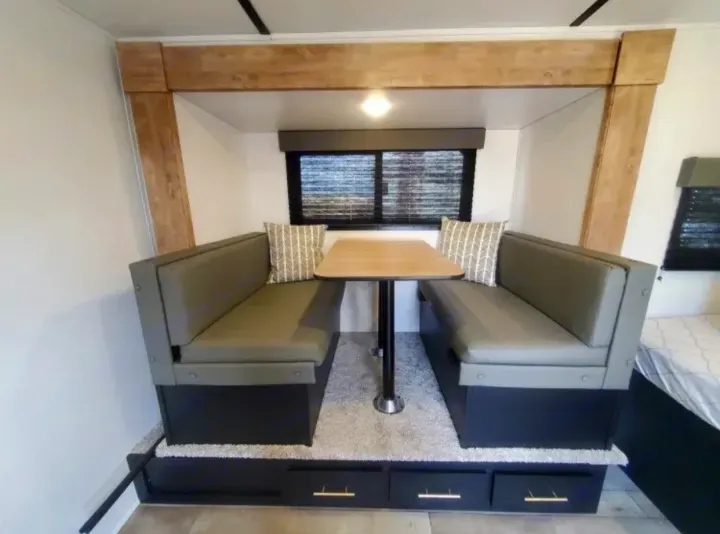 RV rental features a versatile dinette with cozy bench seating, a table, and drawers for storage/bed conversion.. Keystone RV Springdale 2022